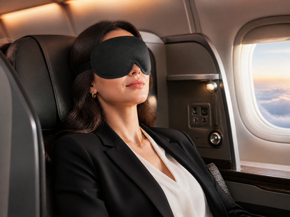Traveler using DriftKit 3D sleep mask on a red-eye flight
